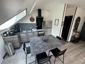 a kitchen with a table and chairs in a kitchen at ARconciergerie Logement cosy centre-ville in Maisse