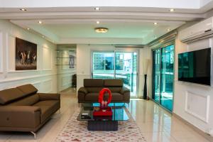 a living room with a couch and a tv at Villa Princess Douala Bali in Douala