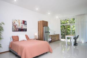 a bedroom with a bed and a desk and a window at Riviera Residences in Guanacaste