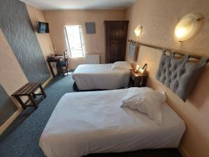 a hotel room with two beds and a window at Logis Hotels - La Table d'Antan - Hôtel 2 étoiles et Restaurant in Bon-Encontre