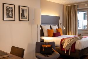 um quarto de hotel com uma cama e uma cadeira em Hotel D - Design Hotel em Basileia