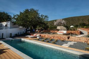 een zwembad in een tuin met stoelen en een tafel bij Glamping Casa Esteval in Rocha Amarela