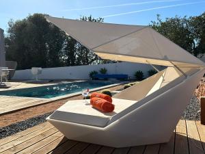een witte tafel met een glas wijn en een boot bij Glamping Casa Esteval in Rocha Amarela