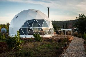 een groot wit koepelgebouw op een veld bij Glamping Casa Esteval in Rocha Amarela