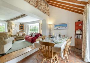 a dining room with a table and chairs and a living room at Clare Cottage in Melton Constable