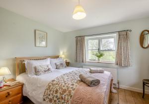 a bedroom with a large bed and a window at Clare Cottage in Melton Constable