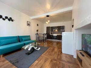 a living room with a blue couch and a table at cocon de Villeneuve-4 pers. in Villeneuve-sur-Yonne