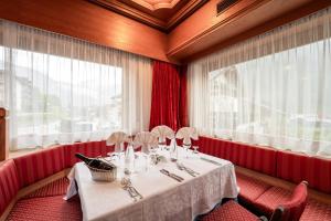 una sala da pranzo con tavolo e finestra di Hotel Grohmann a Campitello di Fassa