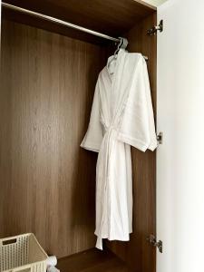 a white robe hanging on a closet door at SAFFRON Dalat in Da Lat