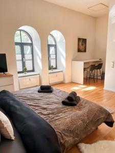 een slaapkamer met een groot bed, 2 ramen en een piano bij Loftstyle I WLAN I Stellplatz in Dresden