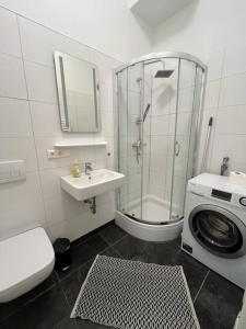 een badkamer met een douche, een wastafel en een wasmachine bij Loftstyle I WLAN I Stellplatz in Dresden