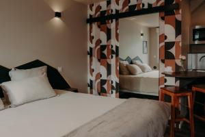 Una habitación de hotel con dos camas y un espejo. en Le Central Hôtel-Bar, en Oloron-Sainte-Marie