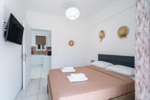 1 dormitorio con 1 cama con 2 toallas en Casa Albastra Rooms & Suites en Porto Heli