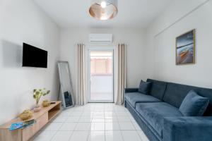 ポルト・ヘリにあるCasa Albastra Rooms & Suitesのリビングルーム(青いソファ、テレビ付)
