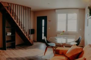 Una sala de estar con una mesa y una escalera. en Le Central Hôtel-Bar, en Oloron-Sainte-Marie
