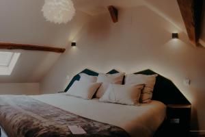 Un dormitorio con una cama grande con almohadas blancas. en Le Central Hôtel-Bar, en Oloron-Sainte-Marie 56 fotos más