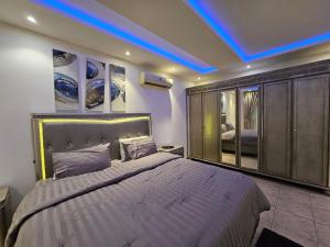 um quarto com uma cama grande e uma luz azul em Friends em Riyadh
