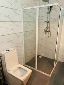 uma casa de banho com um WC e um chuveiro em Chambre SDB simple avec accès piscine em Sali Poulang