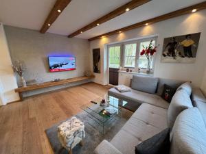 a living room with a couch and a tv at Appartements Ski Rent Michael in Kitzbühel