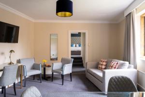 a living room with a couch and chairs and a table at Whately Hall Hotel in Banbury