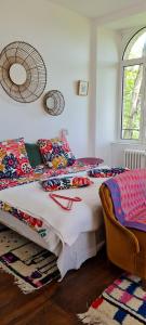 um quarto com uma cama com cobertores e almofadas coloridos em Manoir du Haut Jussé em Vezin-le-Coquet