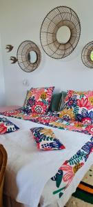 uma cama com almofadas coloridas e espelhos na parede em Manoir du Haut Jussé em Vezin-le-Coquet