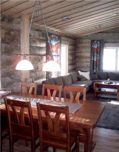 sala de estar con mesa de madera y sillas en Villa Laattamaja - High quality genuine loghouse, en Ylläsjärvi