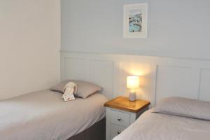sypialnia z 2 łóżkami i lampką na stoliku nocnym w obiekcie Seaside Cottage 2 Bedroom - Bron-Y-Wendon Holiday Park w mieście Llanddulas