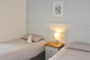 ein Schlafzimmer mit 2 Betten und einer Lampe auf einem Nachttisch in der Unterkunft Seaside Cottage 2 Bedroom - Bron-Y-Wendon Holiday Park in Llanddulas