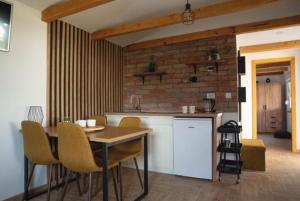 a kitchen with a table and chairs in a room at Apartman River in Belišće