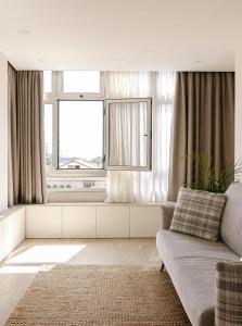sala de estar con sofá y ventana en Las Canteras con Alma, en Las Palmas de Gran Canaria