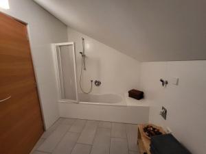 a white bathroom with a shower and a tub at Großschlipfhof in Silandro +32 photos
