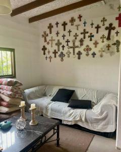 Sala de estar con sofá y cruces en la pared en Casa Pachacamac 'Pan de Azúcar', en Pachacámac