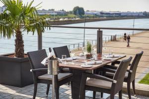 a table and chairs on a patio with a view of the water at Steigenberger Hotel Bremen in Bremen +34 photos