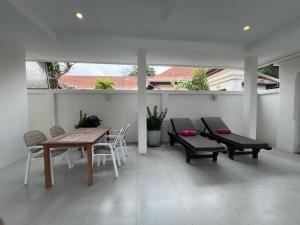 a patio with a wooden table and chairs at VIEW TALAY VILLA POOL HOUSE 285 in Jomtien Beach