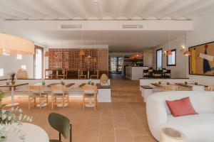 ein Wohnzimmer mit einem weißen Sofa und einem Esszimmer in der Unterkunft Boutique Hotel Villa Salvador - Adults Only by Fimedhotels in Cadaqués