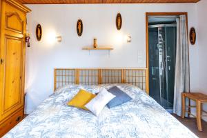 Schlafzimmer mit einem Bett mit gelben und blauen Kissen in der Unterkunft Chambre sous les mimosas 2kms plage in Saint-Jean-de-Monts
