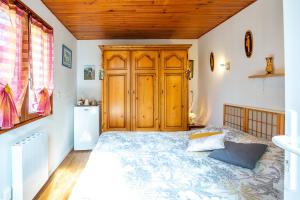 a bedroom with a bed and a wooden cabinet at Chambre sous les mimosas 2kms plage in Saint-Jean-de-Monts