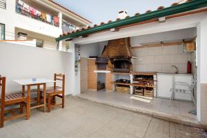 uma grande cozinha exterior com um grande forno de pizza em Casa da Cândida na Nazaré