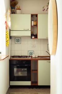 a kitchen with white cabinets and a black oven at Le Case della Costa - Appartamento Capri in Maiori +6 photos