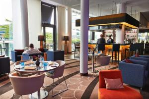 a restaurant with tables and chairs and a bar at Steigenberger Hotel Bremen in Bremen