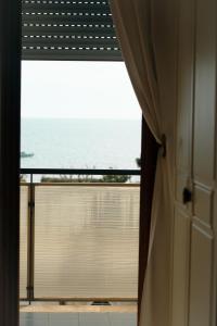 a room with a view of the ocean from a window at Le Case della Costa - Appartamento Capri in Maiori