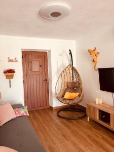 a room with a swinging chair and a television at Paraíso a Dois em Estremoz in Estremoz