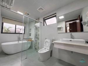 a bathroom with a tub and a toilet and a sink at Rosa Villa - Sonasea Vân Đồn in Cái Rồng