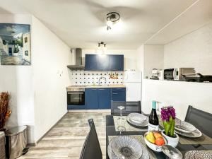 cocina y comedor con mesa y cocina con armarios azules en Apartment Milan Hvar-Quiet Oasis, en Hvar