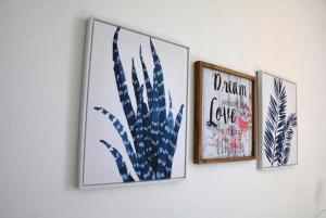 tres fotos de plantas en una pared blanca en BLife Faro Beach Hostel, en Faro