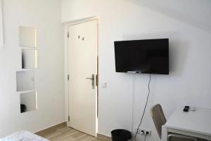 Habitación con puerta y TV en la pared en BLife Faro Beach Hostel, en Faro