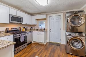 een keuken met een fornuis, een wasmachine en een droger bij Family-Ready 3BR Home, Pets OK, Near Downtown in Atlanta