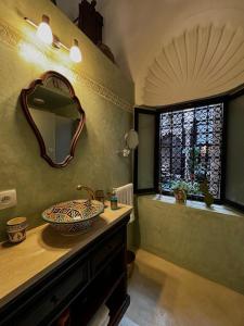 baño con lavabo, espejo y ventana en RiadLalZahra en Rabat