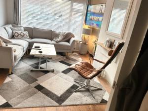 uma sala de estar com um sofá e uma cadeira em The Heath Retreat em Whitstable